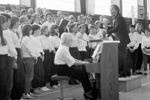 ARH Slg. Weber 02-132/0021, Auftritt eines gemischten Chors mit Jugendlichen und Chorleiter Erich Kolb in der Sporthalle Lange Feldstraße, Gehrden, zwischen 1980/1990
