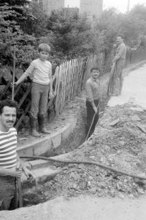 ARH Slg. Weber 02-133/0008, Arbeiter verlegen ein Kabel in einem Loch neben einer Straße, zwischen 1980/1990