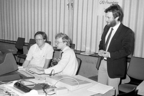 ARH Slg. Weber 02-136/0009, V.l. N.N. und und Heinz Mensing von EDV Rath&Mensing an einem Computer zur Vorführung von CAD-Anwendungen mit Reiner Rath (stehend), zwischen 1980/1990
