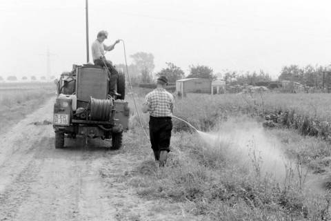 ARH Slg. Weber 02-139/0023, Zwei Männer beim Besprühen eines Feldes mit einem Wagen, zwischen 1980/1990