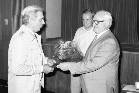 ARH Slg. Weber 02-141/0002, Gehrdens Bürgermeister Helmut Oberheide (rechts) überreicht Ratsherr Helmut Grefe einen Blumenstrauß, dahinter Stadtdirektor Hans Bildhauer, zwischen 1980/1990