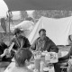 Archiv der Region Hannover, ARH NL Mellin 01-148/0017, Menschen beim Essen unter einem Zeltvordach sitzend