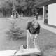 Archiv der Region Hannover, ARH NL Mellin 01-159/0025, Mann baut eine Sitzbank aus halbierten Baumstämmen
