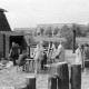 Archiv der Region Hannover, ARH NL Mellin 01-166/0003, Gruppe von Menschen neben einer Holzhütte