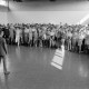 ARH NL Mellin 01-196/0017, Ein Mann (Lehrer?) steht vor versammelten Schüler*innen in einer Sporthalle