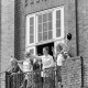 ARH NL Mellin 01-198/0008, Zwei Frauen und ein Mann im Hofnarr(?)-Kostüm auf dem Balkon des Rathauses stehend und nach unten blickend, Lehrte