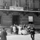 ARH NL Mellin 02-094/0018, Hochzeitsgesellschaft vor dem Mairie de Vanves (Rathaus) mit einem Werbeschild für eine Gala mit deutschen Volksliedern, aufgeführt vom Schulchor aus Burgdorf, Vanves