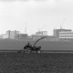 ARH NL Mellin 02-100/0008, Traktor beim Pflügen eines Feldes, im Hintergrund ein Neubaugebiet, Burgdorf?