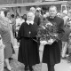 Archiv der Region Hannover, ARH NL Mellin 02-132/0005, Zwei Geistliche mit einer Blume im Topf laufen durch die Menschenmenge auf dem Altstadtmarkt an der St. Martini-Kirche, Braunschweig