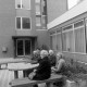 ARH NL Mellin 02-162/0003, Gruppe von älteren Damen auf Bänken vor einem Gebäude sitzend