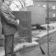 Stadtarchiv Neustadt a. Rbge., ARH Slg. Bartling 13, Ratsherr und Bürgermeister Herbert Gubba betrachtet eine Mauerecke, die in den Bürgersteig ragt (bei Firma Schlüter beim Umbau des Bahnhofs)