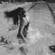 Stadtarchiv Neustadt a. Rbge., ARH Slg. Bartling 421, Aus dem Wasser aufspringendes Mädchen im Schwimmerbecken des Hallenbades