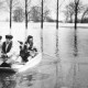 Stadtarchiv Neustadt a. Rbge., ARH Slg. Bartling 476, Zwei Männer paddeln in Pünte bei Hochwasser