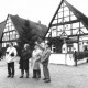 Stadtarchiv Neustadt a. Rbge., ARH Slg. Bartling 548, Giebel der beiden Fachwerkhäuser in der Windmühlenstraße 19 und 20, davor vier Männer, die das gegenüberliegende Haus am Hufeisenweg begutachten