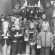 Stadtarchiv Neustadt a. Rbge., ARH Slg. Bartling 834, Kinder und Personal des Kindergartens am Krankenhaus (?) zeigen ihre Weihnachtsbastelei, Neustadt a. Rbge.