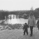 Stadtarchiv Neustadt a. Rbge., ARH Slg. Bartling 1127, Spaziergang einer jungen Familie mit zwei Kindern auf dem schneebedeckten Eis am reetbewachsenen Ufer des Sees, Steinhuder Meer