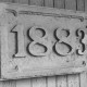 Stadtarchiv Neustadt a. Rbge., ARH Slg. Bartling 1514, Sandsteinplatte mit der Jahreszahl "1883" nach der Neuplatzierung am neuen Freizeitzentrum, Neustadt a. Rbge.