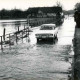 Stadtarchiv Neustadt a. Rbge., ARH Slg. Bartling 1571, Leine-Hochwasser am Fährhaus, Männer auf dem Steg, ein PKW (Ford Taunus 20 M P 7) bei der Fahrt durch das Wasser über die Brücke, Bordenau