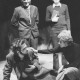 ARH Slg. Bartling 1740, Kniende Schauspielerin befasst einen auf den Boden gefallenen Mann, der mit Uniformmantel bekleidet ist, hinter den beiden zwei Männer stehend, Neustadt a. Rbge.