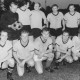 Stadtarchiv Neustadt a. Rbge., ARH Slg. Bartling 1976, Mannschaft des TSV Poggenhagen (nebeneinander kniend und stehend) mit Sieger-Pokal auf dem FC Wacker-Sportplatz, Neustadt a. Rbge.