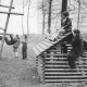 Stadtarchiv Neustadt a. Rbge., ARH Slg. Bartling 2147, Kinder beim Klettern an Spielgeräten aus Holz auf einem Spielplatz, im Hintergrund hinter einem Wall zwei Wohnhochhäuser, Berenbostel