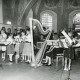 ARH Slg. Bartling 2160, Dora Kolesch (l.) beim Dirigat eines Jugendorchesters u. a. mit Blockflöten und Harfe im Altarraum der Kirche, Blick in die Apsis, Basse