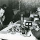 ARH Slg. Bartling 2276, Schachpartie (mit Schachuhr, neben Pokal) zwischen zwei Männern in einem Motel, Neustadt a. Rbge.