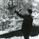 ARH Slg. Bartling 2484, Jagdpächter Dr. med. dent. Henning Gode gestiefelt und gespornt im winterlichen Garten im hohen Schnee stehend mit einem Bussard beim Abflug von der ausgestreckten Hand, Kreisjägerschaft, Neustadt a. Rbge.