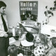 Stadtarchiv Neustadt a. Rbge., ARH Slg. Bartling 3370, Belehrung von Kindergartenkindern durch einen jungen Polizisten (l.), Blick über die Hinterköpfe der Kinder auf einen Tisch mit Lernmaterial, Neustadt a. Rbge.