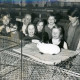 ARH Slg. Bartling 3612, Präsentation eines auf einem Drahtkäfig sitzenden weißen Angorakaninchens für eine Gruppe von Kindern durch N. N. während der Ausstellung F 1 73 in der Gastwirtschaft Walter Rubrecht, Landwehr 26, Neustadt a. Rbge.
