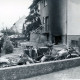 ARH Slg. Bartling 3686, Brand in der Kellergarage eines Zweifamilienhauses, Blick über zwei an eine Stützwand angelehnte ausgebrannte Motorräder auf die Hausecke mit rauchgeschwärzter Garageneinfahrt und Hauseingang, Neustadt a. Rbge.