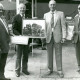 ARH Slg. Bartling 3717, Vier ältere Herren nebeneinander stehend auf der Terrasse eines Lokals, drei Herren mit historischen Bildern in der Hand, Mardorf