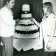 ARH Slg. Bartling 3735, Vierstöckige Torte mit der Aufschrift ".WK 10 Jahre", links daneben ein Koch in Berufskleidung, rechts eine Angestellte in weißem Kittel, Schneeren