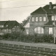 Stadtarchiv Neustadt a. Rbge., ARH Slg. Bartling 4088, Blick von Westen über die Gleise auf das Bahnhofsgebäude und die Gaststätte Schrader (l.), Eilvese