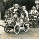 Stadtarchiv Neustadt a. Rbge., ARH Slg. Bartling 4149, Beteiligung der Kinder mit Blumen-geschmückten Bollerwagen beime Erntefestumzug, im Hintergrund Lehrer Alfred Odwald, Empede