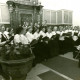 Stadtarchiv Neustadt a. Rbge., ARH Slg. Bartling 4183, Chorkonzert in der Kirche, Blick auf den Kirchenchor, der vor dem barocken Altar steht, rechts die Dirigentin, Hagen