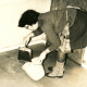 ARH Slg. Bartling 4244, Überschwemmung im Neubaugebiet, Frau schaufelt mit Kehrblech das Hochwasser im Keller in einen Eimer, Helstorf