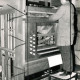 Stadtarchiv Neustadt a. Rbge., ARH Slg. Bartling 4266, Orgelbauer auf dem Stuhl stehend bei Reparaturarbeiten am geöffneten Spielschrank in der Kirche, Helstorf