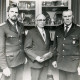 ARH Slg. Bartling 4431, Ehrung von drei Feuerwehrleuten, stehend vor einer mit Pokalen und Tellern gefüllten Vitrine, rechts: W. Oehlerking, Mandelsloh