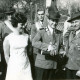 ARH Slg. Bartling 4647, Schützenkönig stehend mit Flasche in der Hand, neben und hinter ihm uniformierte bzw. chargierte Schützenbrüder, links eine Dame in weißem Kleid beim Schützenfest, Metel
