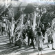 Stadtarchiv Neustadt a. Rbge., ARH Slg. Bartling 4704, Umzug mit einer Gruppe von Kindern, die Stangen schwenken, an deren Spitzen bunte Streifenbüschel befestigt sind beim Schützenfest, Nöpke