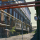 Archiv der Region Hannover, ARH Slg. Bürgerbüro 13, Blick durch den Zaun auf das Gebäude der ehemaligen Hanomag Maschinenbau AG, Linden