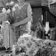 Archiv der Region Hannover, ARH Slg. Weber 02-003/0005, Eine Frau mit einem Blumenstrauß in der Hand steht an einem Wochenmarkt-Stand? mit unterschiedlichen Waren